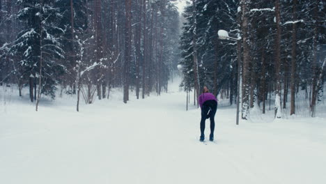 WIDE-TRACKING-Back-view-of-young-adult-Caucasian-female-athlete-skiing-downhill-on-a-skirun.-4K-UHD-60-FPS-SLO-MO